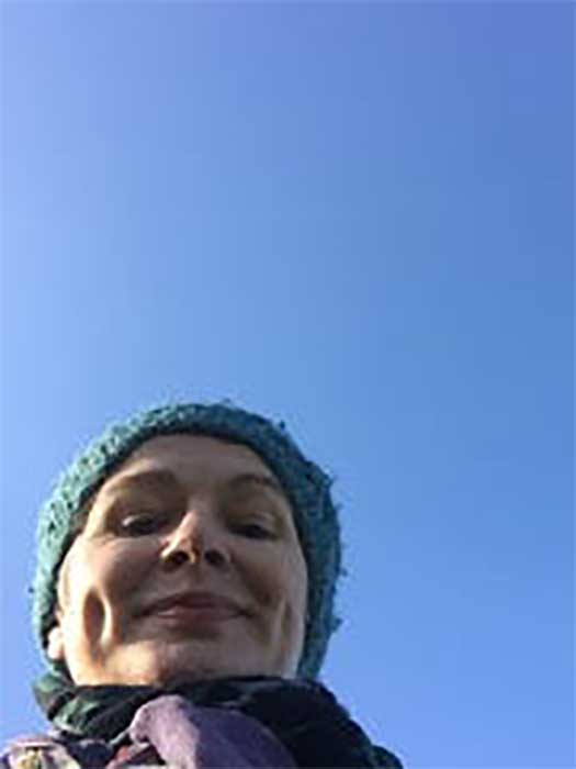 Anne Scallan in hand knit blue beanie against bright blue Irish sky (doesn’t happen often).