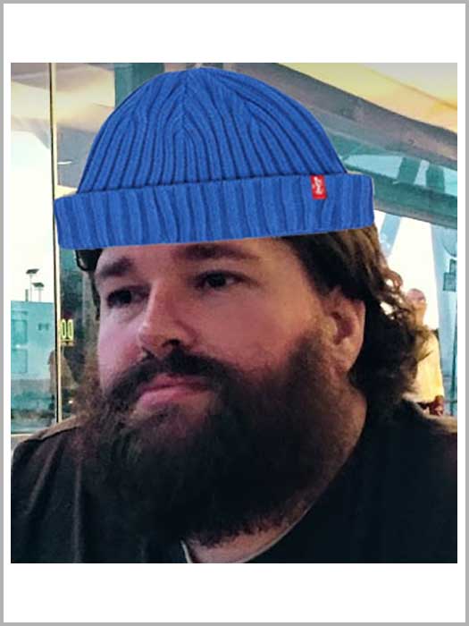 Ian Pouncey with clearly-pasted on blue beanie balancing against his luscious beard.