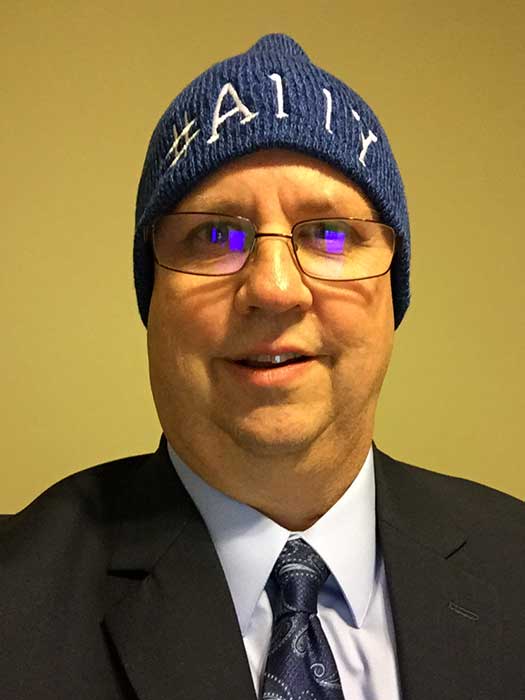 Mike Paciello with a blue beanie that has #a11y embroidered on it.