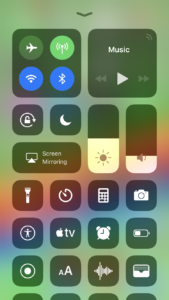 The iOS control centre screen shown with Reduce Transparency off. The iPhone screen wallpaper is partially viewable via a transparency effect behind the control centre.