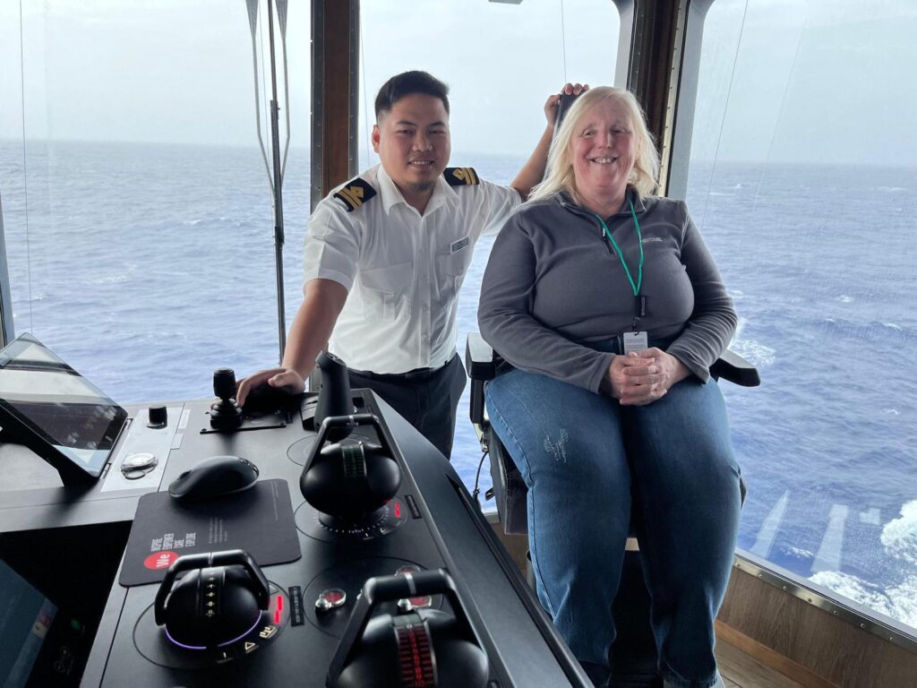 Isabel Holdsworth with the captain by the controls inside the boat.
