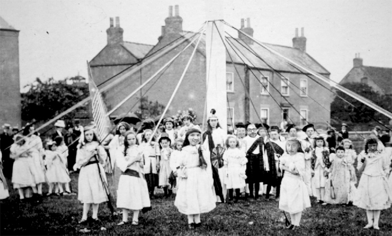 Children including David, Patrick and Jonny, dance around a maypole.