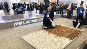 A man traversing a carpet and a bed of woodchips while in a Whill EV